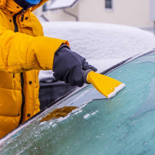 ice scraper on snowy windshield